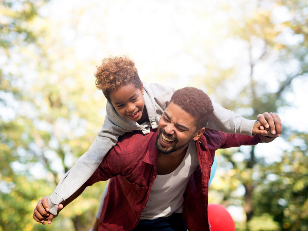 father-holding-his-daughter-on-shoulders-and-laughing